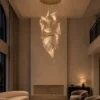 Auretta gold cascading LED chandelier in a contemporary high-ceiling living room