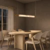 Bahari Bronze Gold linear chandelier above a contemporary dining table
