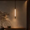 Clio Vertical brown and pearl black chandelier illuminating a contemporary interior