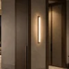 Keaton Gun Black linear wall lamp illuminating a modern hallway
