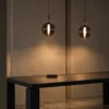 Siris Round copper pendant lights arranged above a modern dining table