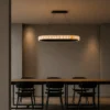 Soma Cylindrical dark brown chandelier illuminating a modern dining interior