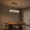 Valor Oval coffee gold chandelier above a contemporary dining table
