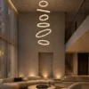 Valor Staircase coffee gold cascading ring chandelier in a high-ceiling living room