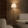 Vansa brushed bronze floor lamp illuminating a modern living room