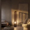 Zora walnut sculptural floor lamp illuminating a modern living room