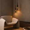Abramo Smoky Glass Pendant Lights Living Room Abramo smoky glass pendant lights arranged at varying heights beside a modern lounge chair