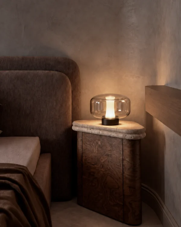 Adina table lamp displayed beside a bed in a contemporary interior