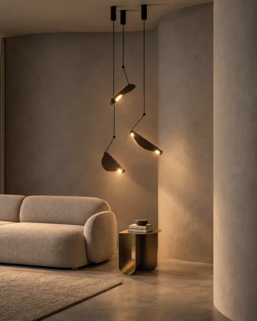 Aion sculptural pendant light with three angled shades beside a modern upholstered sofa
