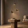 Aion three-light pendant arrangement suspended above a wooden side table in a contemporary interior