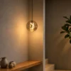 Akie amber glass pendant light illuminating a warm contemporary interior with wooden furnishings