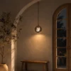 Akie glass pendant light providing warm illumination beside an arched window in a contemporary interior