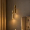 Amalea Gold Pendant Lights Bedroom Two Amalea gold cylindrical pendant lights suspended beside a contemporary upholstered bed