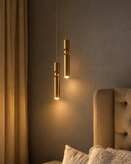 Amalea Gold Pendant Lights Bedroom Two Amalea gold cylindrical pendant lights suspended beside a contemporary upholstered bed