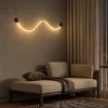 Archer sculptural wave wall lamp providing soft ambient illumination above a modern lounge sofa