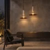 Two Asteria Gold pendant lights suspended above a contemporary living room seating area