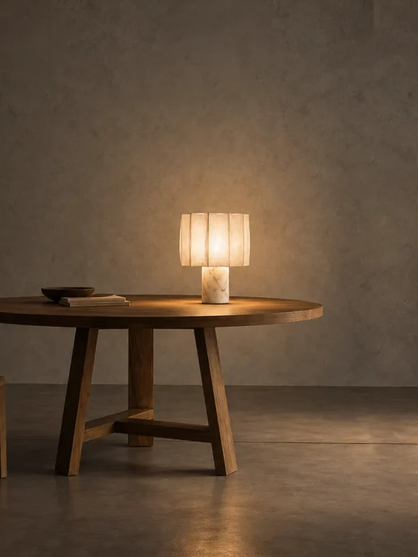 Astra white decorative table lamp displayed on a round wooden table in a warm minimalist interior