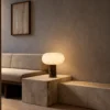 Auren Table Lamp Contemporary Interior Auren table lamp with glowing rounded shade on a stone side table beside a sofa