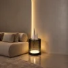 Bellora cylindrical table lamp with Coffee Black finish beside a curved sofa in a modern interior