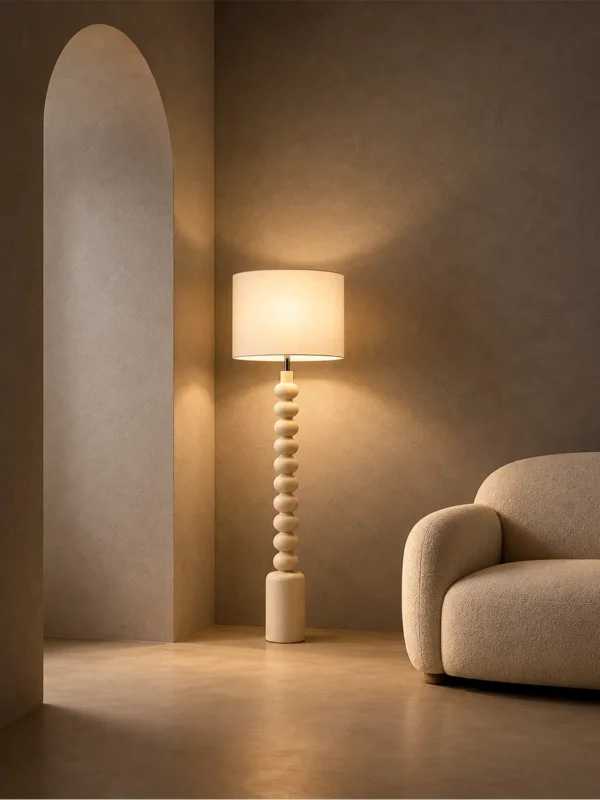 Bianca white sculptural floor lamp beside a curved sofa in a warm contemporary living room