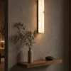 Bianco vertical wall lamp above a floating wooden shelf in a warm modern interior