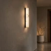 Bianco illuminated wall lamp mounted on a textured wall in a contemporary hallway