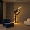 Civil Gymnast black resin floor lamp featuring an illuminated ribbon beside modern lounge chairs