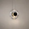 Dione Sculptural Glass Pendant Light Dione pendant light featuring rounded transparent glass and a dark circular center