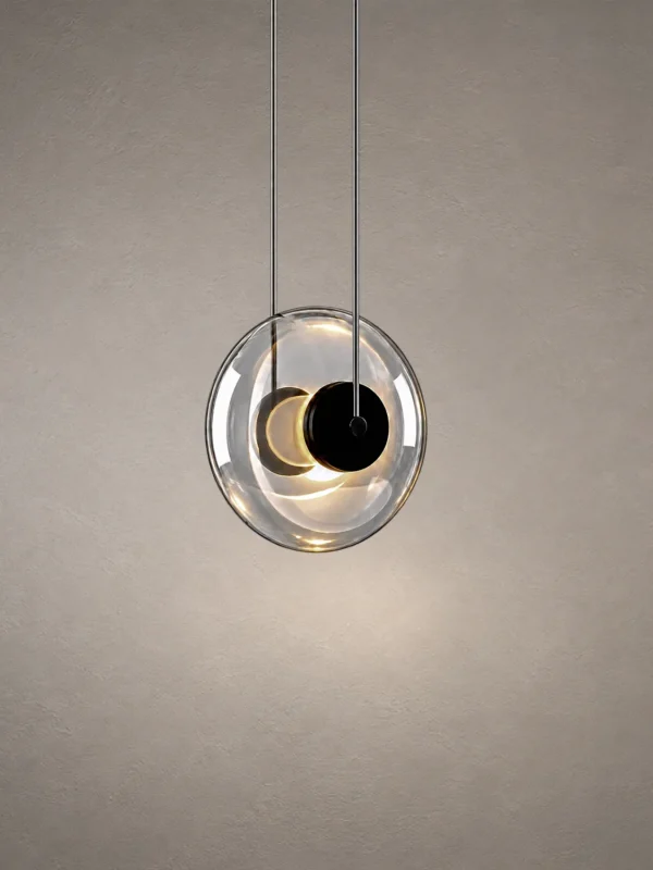 Dione pendant light featuring rounded transparent glass and a dark circular center