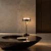 Elion Table Lamp Contemporary Interior Elion circular table lamp with Pearl Black and Chrome finishes on a dark round table