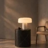 Elvera Table Lamp Black Marble Interior Elvéra table lamp with illuminated white shade displayed on a black marble pedestal