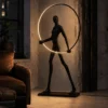 Humano Round sculptural black floor lamp illuminating a warm contemporary interior beside a window