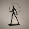 Humano Round black sculptural floor lamp featuring a human figure holding an illuminated circular ring