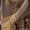 Kendra 18 sculptural chandelier in Black and Gold beside a contemporary staircase