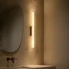 Leti vertical wall lamp beside a mirror in a modern bathroom