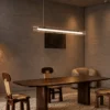 Linia Chandelier Dining Room Interior Linia linear chandelier suspended above a wooden dining table in a contemporary interior
