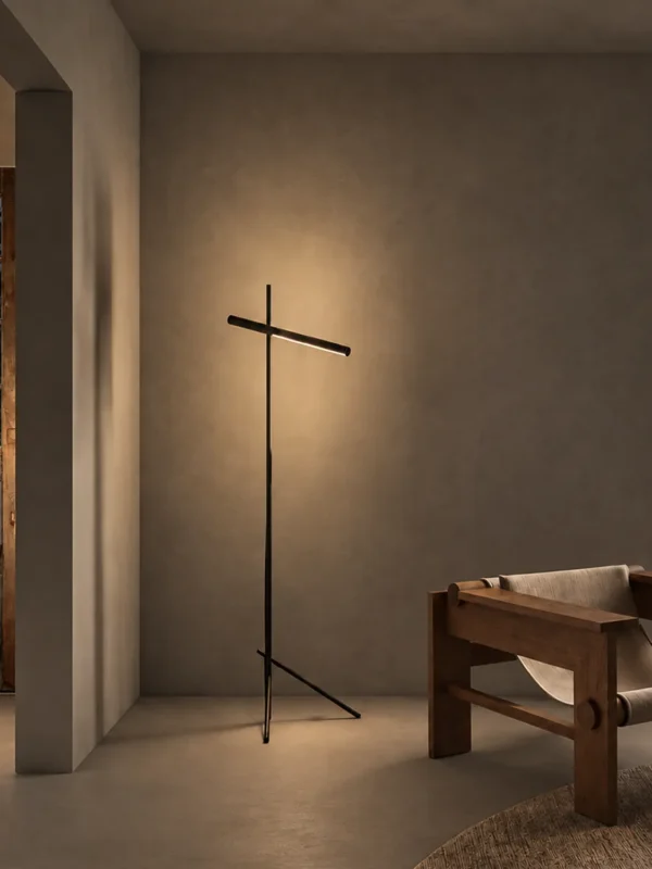 Mithra linear floor lamp with black finish positioned beside a wooden bench in a modern interior