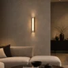 Miyake Strip Wall Lamp Modern Living Room Miyake Strip linear wall lamp mounted beside a curved sofa in a warm contemporary living room