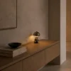 Nero Table Lamp Contemporary Console Nero table lamp with reflective metallic shade displayed on a wooden console