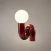 Noelle Maroon Sculptural Table Lamp Noelle modern maroon table lamp featuring a glowing spherical glass shade and curved resin base