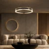 Oriel Chandelier Contemporary Living Room Oriel illuminated ring chandelier above a modern living room seating area with a curved sofa