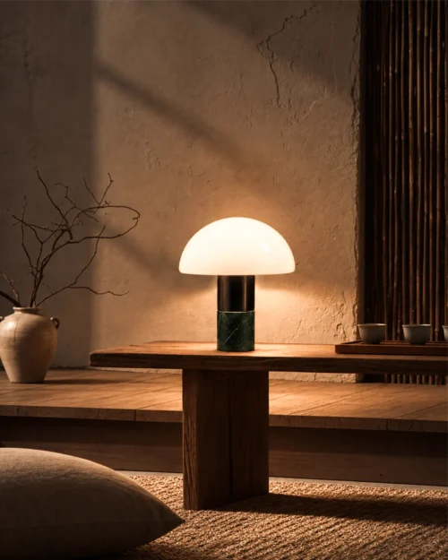 Orly green table lamp with a glowing white dome-shaped shade on a wooden console table