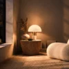 Orly white mushroom table lamp on a wooden side table beside a contemporary upholstered chair