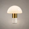 Orly modern table lamp with a white dome-shaped glass shade, gold metallic detailing, and white marble base