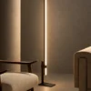 Perun minimalist floor lamp with Black and Coffee finishes beside modern upholstered seating