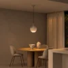 Ronde glass pendant light suspended above a round dining table in a contemporary interior