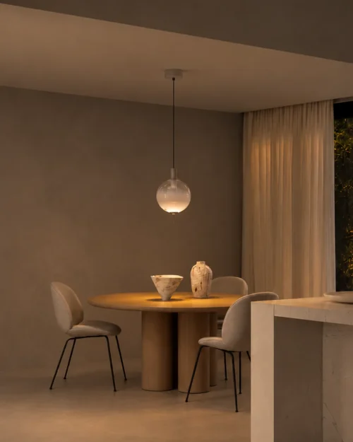Ronde glass pendant light suspended above a round dining table in a contemporary interior