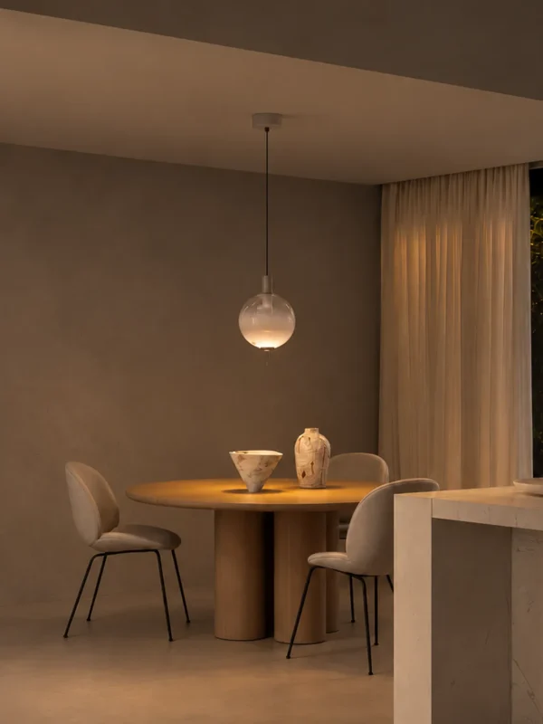 Ronde glass pendant light suspended above a round dining table in a contemporary interior