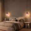 Two Ronde pink glass pendant lights suspended beside a bed in a modern bedroom