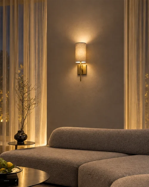 Serafina decorative wall lamp with a grey fabric shade mounted above a contemporary living room sofa